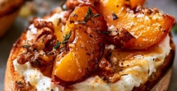 Roasted plum crostini topped with whipped Brie cheese, candied pecans, fresh thyme, and honey on toasted baguette.
