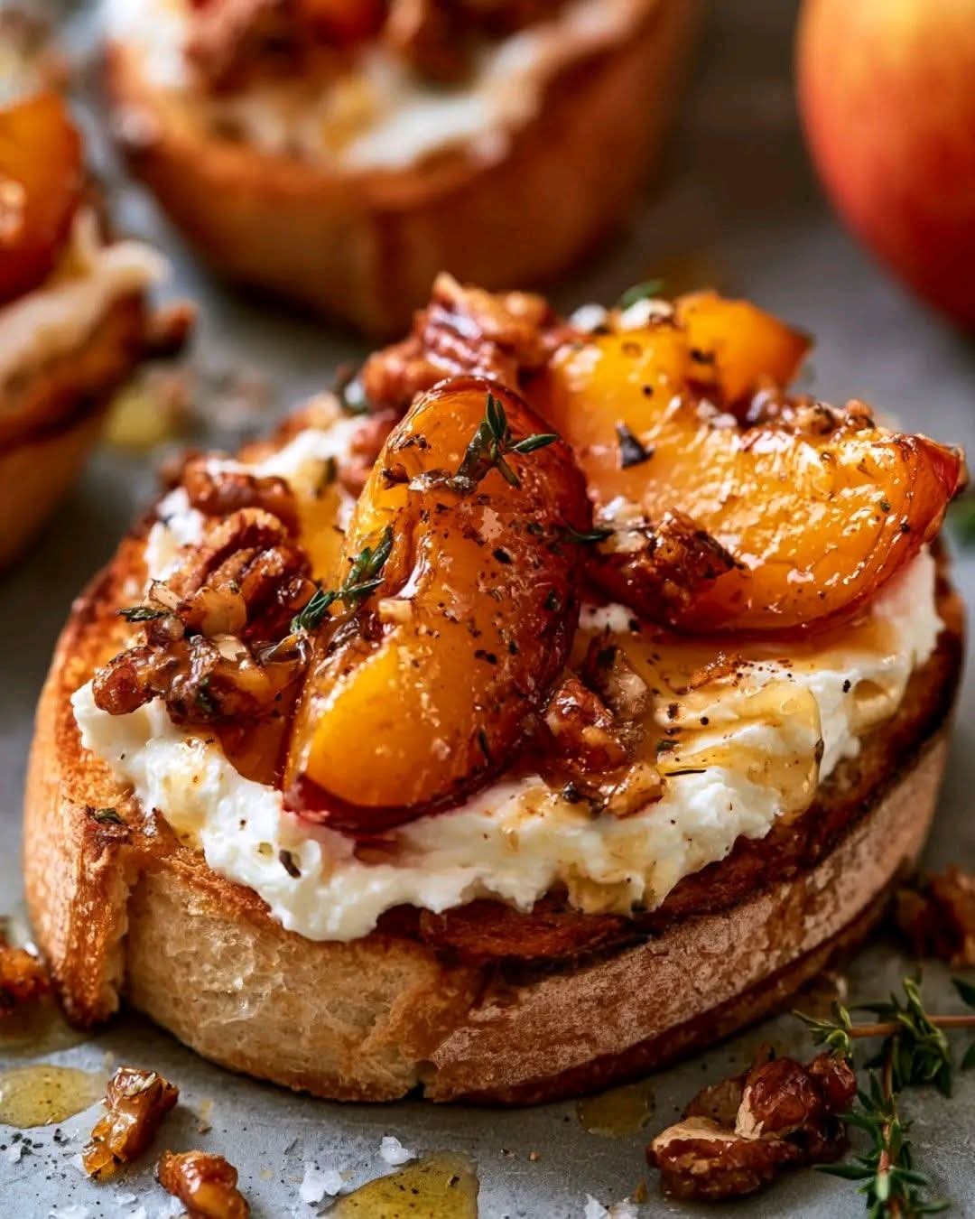 Roasted plum crostini topped with whipped Brie cheese, candied pecans, fresh thyme, and honey on toasted baguette.