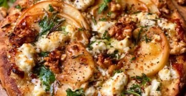 Homemade apple feta walnut flatbread topped with fresh rosemary, toasted walnuts, arugula, and honey drizzle on a crispy artisan crust.