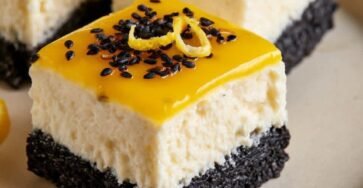 Black Sesame Lemon Cloud Cheesecake Cubes with creamy no-bake lemon cheesecake, black cookie sesame crust, glossy lemon curd topping, toasted black sesame seeds, and fresh lemon zest.