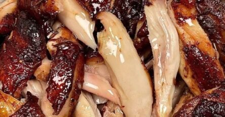 Juicy glazed roasted chicken pieces with crispy caramelized skin served in a white bowl.