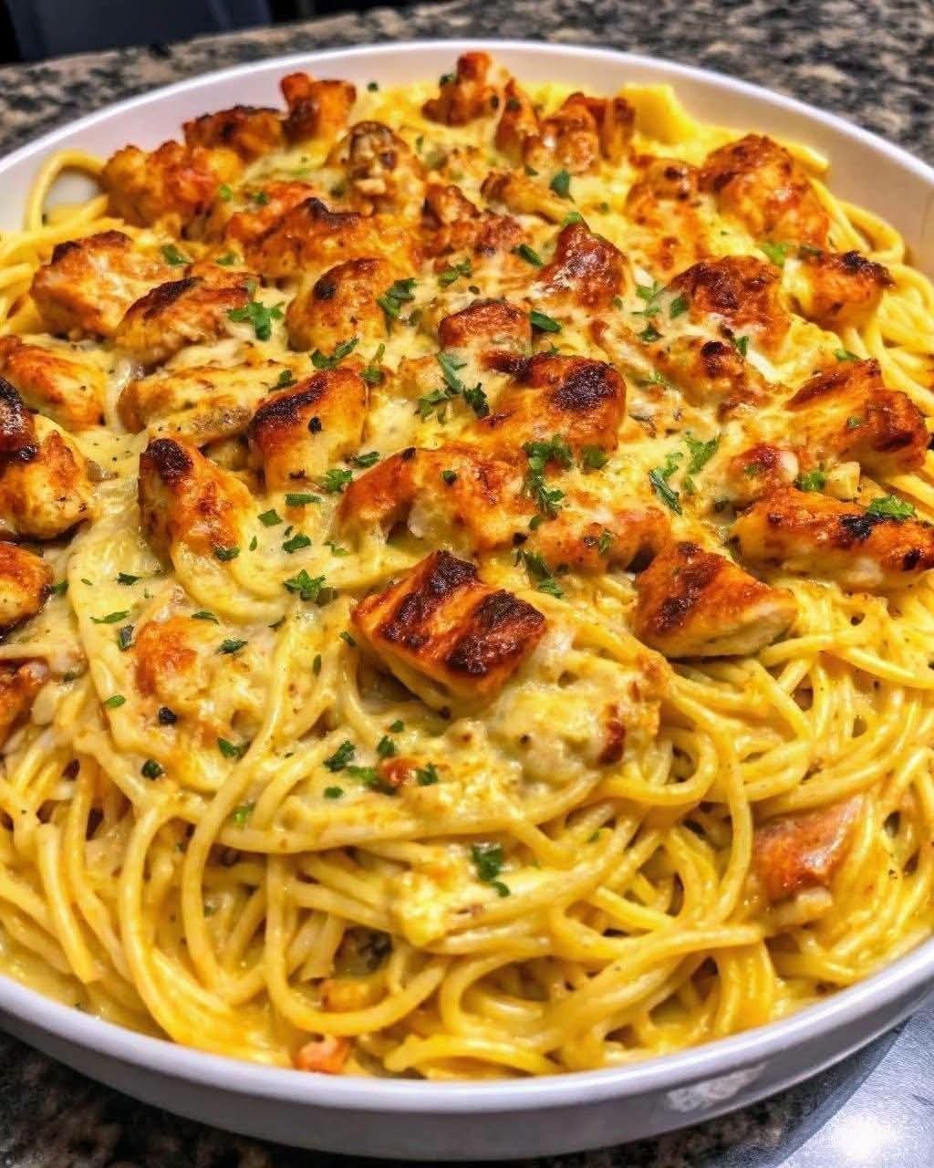 Creamy Monterey Jack chicken spaghetti topped with golden seasoned chicken pieces, melted cheese, and fresh parsley.