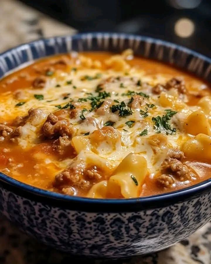Creamy slow cooker lasagna soup with ground beef, tender noodles, tomato broth, and melted mozzarella cheese