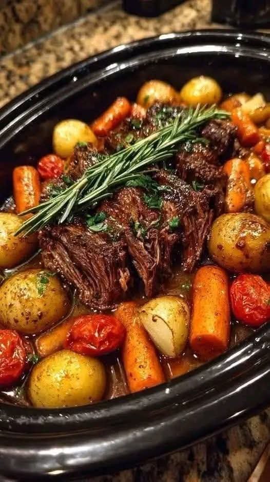 Tender Italian slow cooker pot roast with carrots, potatoes, tomatoes, and fresh rosemary