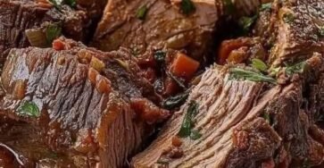 Tender Italian slow-cooked pot roast with beef chuck, tomato sauce, carrots, and fresh herbs