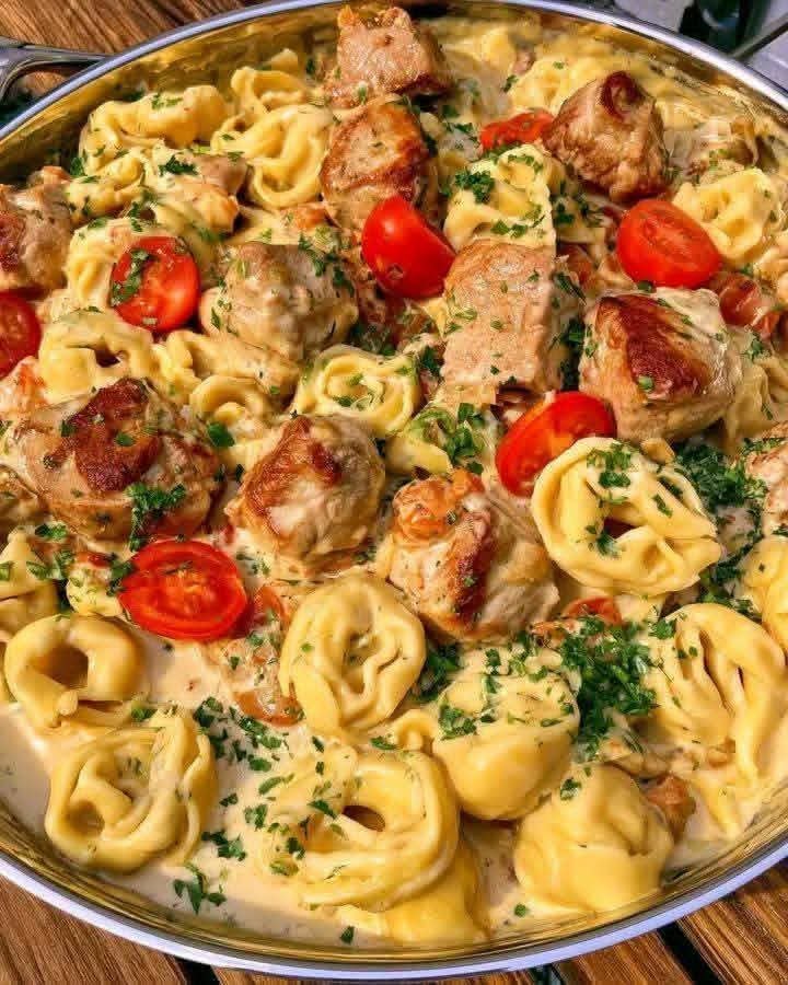 Creamy chicken tortellini with Parmesan garlic sauce, cherry tomatoes, and fresh parsley