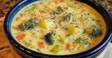 Classic egg drop soup with egg ribbons, carrots, broccoli, and herbs in a bowl