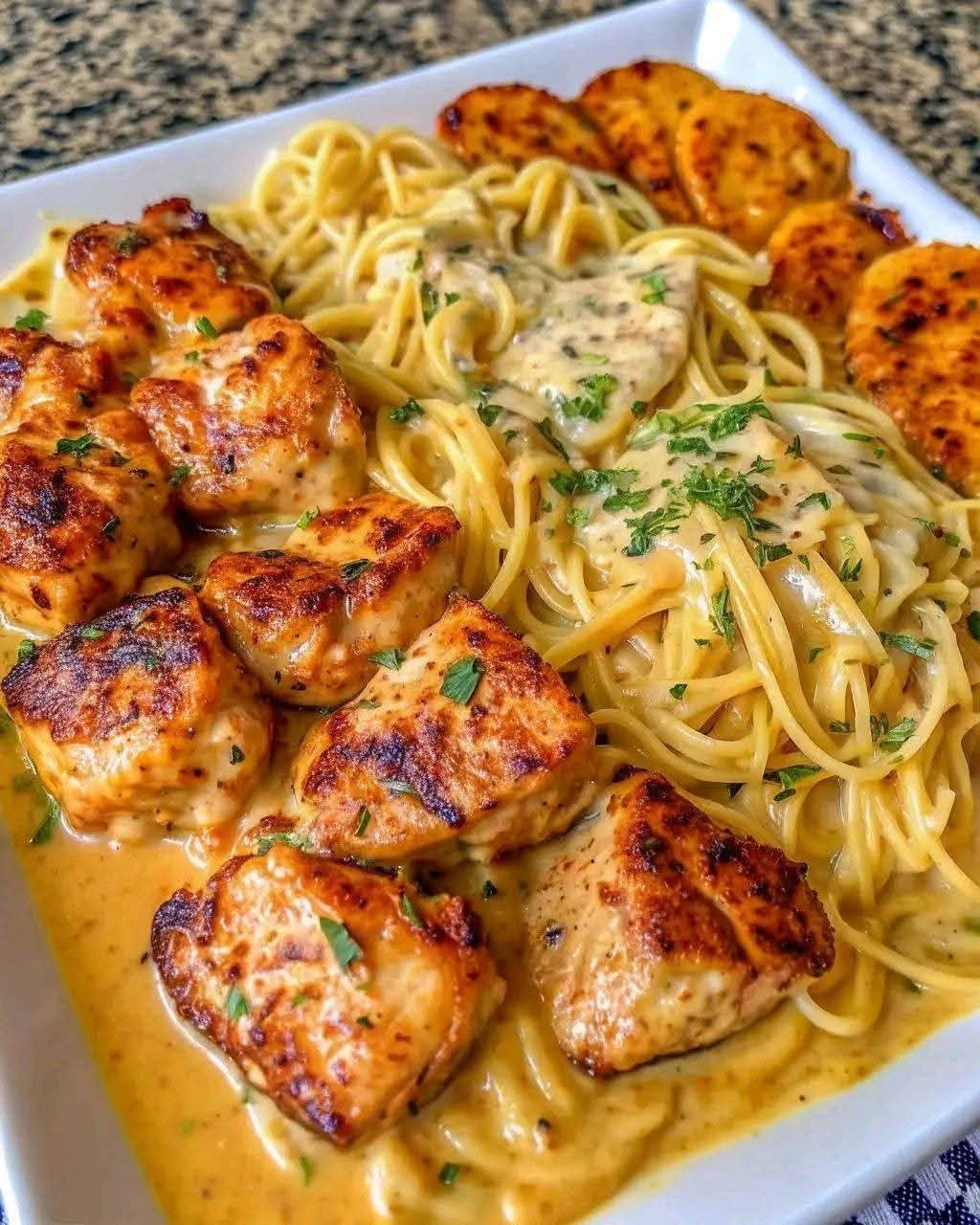 Garlic chicken spaghetti topped with tender seasoned chicken in a creamy three-cheese Alfredo sauce