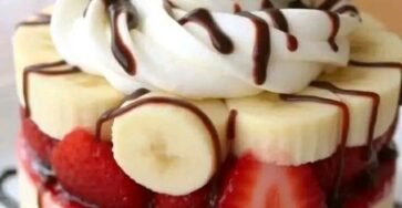 Mini strawberry banana desserts with Chantilly cream, whipped cream, chocolate syrup, and cherries