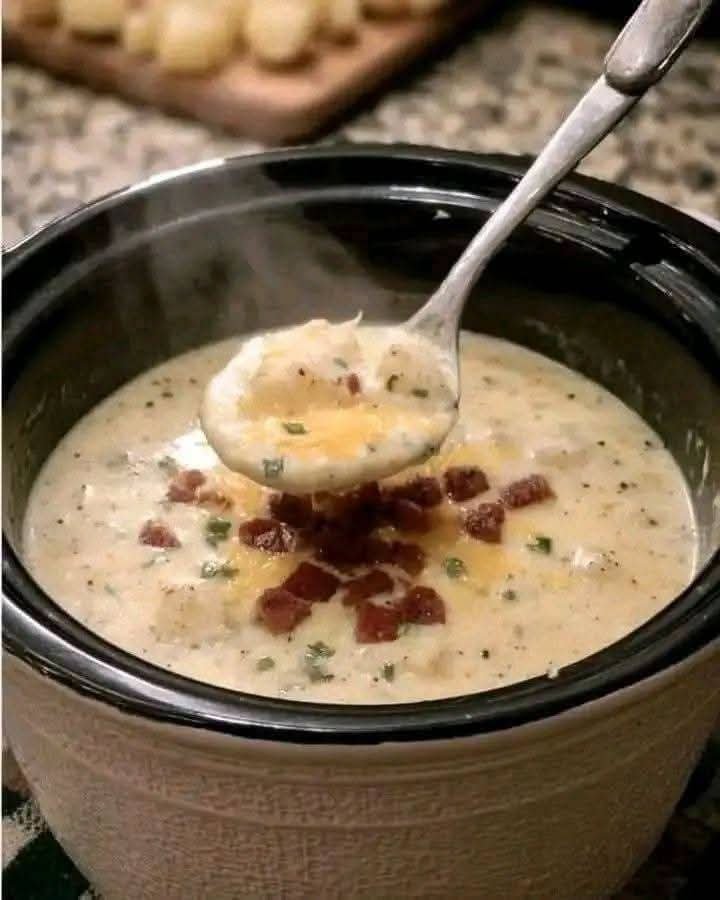 Creamy slow cooker loaded potato soup topped with crispy bacon and herbs